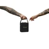 Marshall Stockwell II portable Bluetooth speaker in Black and Brass, carried by the strap