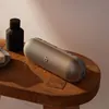 Beats Pill portable Bluetooth speaker in Champagne Gold, with water drops on its surface