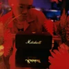 Marshall Emberton III portable Bluetooth speaker in Black and Brass, on a bar table in red light