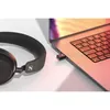 Sennheiser BTD 700 USB-C Bluetooth audio dongle in Black, plugged into a laptop with Momentum 4 Wireless headphones