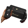 Marshall Middleton II portable Bluetooth speaker in Black and Brass, next to a phone playing music