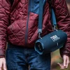 JBL Xtreme 4 portable Bluetooth speaker in Blue, carried on the shoulder strap