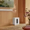 Sonos Sub 4 wireless subwoofer in White, in a living room below a white Arc Ultra