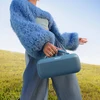 Bose SoundLink Max portable Bluetooth speaker in Blue Dusk, carried by its rope handle outdoors