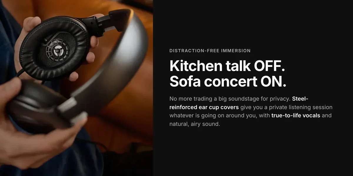 Hands holding Sennheiser HD 620S headphones on a sofa, steel-reinforced ear cup covers for private listening