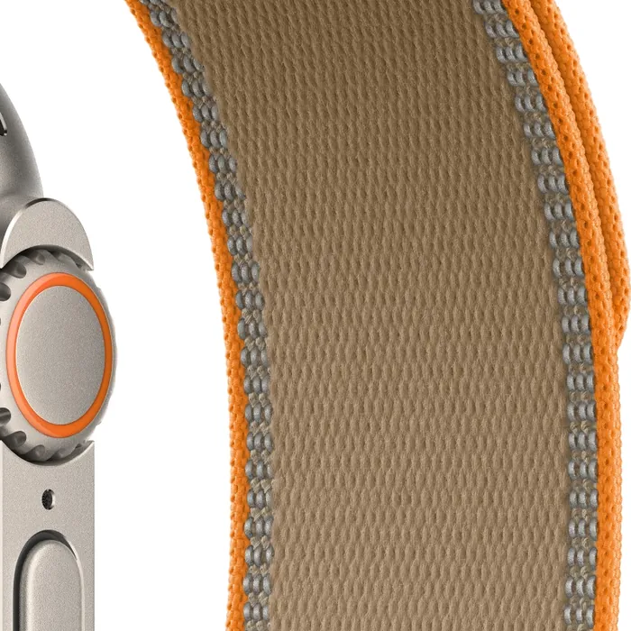 Apple Watch Ultra 4 in Natural Titanium with the Sand Trail Loop, close-up of the Digital Crown, side button and strap with its reflective edges