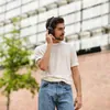 Sennheiser Momentum 4 Wireless noise cancelling headphones in Black, worn outdoors by a man in a white T-shirt