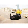 JBL Charge 6 portable Bluetooth speaker in Black, half buried in beach sand