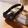 Beats Solo 4 on-ear wireless headphones in Matt Black, on a table, lifestyle