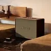Marshall Woburn III Bluetooth home speaker in Brown, beside a bed