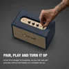 Marshall Acton III Bluetooth home speaker in Midnight Blue, hand turning the volume knob