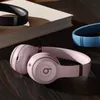 Beats Solo 4 on-ear wireless headphones in Cloud Pink, on a table, lifestyle