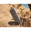 Bose SoundLink Flex (2nd Gen) portable Bluetooth speaker in Sandstone, standing on rocks outdoors