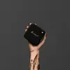 Marshall Willen portable Bluetooth speaker in Black and Brass, held up in one hand