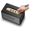 Marshall Acton IV Bluetooth home speaker in Black, hand pulling the power switch on the top panel