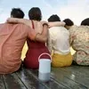 Bose Portable Smart Speaker with Alexa in Luxe Silver, on a wooden jetty with friends