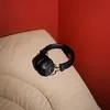 Marshall Major IV wireless on-ear headphones in Black, resting on the arm of a sofa
