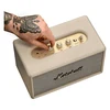 Marshall Acton III Bluetooth home speaker in Cream, hand turning the volume knob