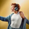 Sennheiser Momentum 4 Wireless noise cancelling headphones in Denim, worn by a woman in a denim jacket