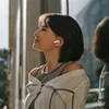 Sennheiser Accentum Open true wireless open-fit earbuds in Cream, worn by a woman, side view