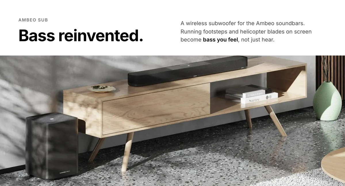 Sennheiser Ambeo Sub wireless subwoofer on the floor beside an Ambeo soundbar on a TV stand