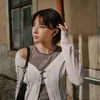 Sennheiser Accentum Open true wireless open-fit earbuds in Black, worn by a woman in a white cardigan