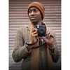 Fujifilm Instax Mini 99 Premium Edition Pack, Black, held with the strap around the neck