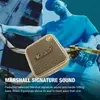 Marshall Willen II portable Bluetooth speaker in Cream, held up by a rider on a bike
