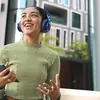JBL Live 770NC wireless over-ear noise cancelling headphones in Blue, worn on a city street