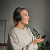Sennheiser HD 569 closed-back headphones in Black, worn while taking a call at home