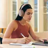 Sennheiser Accentum Wireless noise cancelling headphones in Taupe, worn by a woman working at a laptop