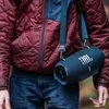 JBL Xtreme 4 portable Bluetooth speaker in Blue, carried on the shoulder strap