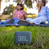 JBL Go Essential 2 portable Bluetooth speaker in Blue, on the grass at a picnic
