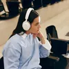 Sennheiser Accentum Wireless noise cancelling headphones in White, worn by a woman in a light blue sweatshirt