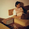 Marshall Stanmore III Bluetooth home speaker in Brown, beside a bed