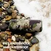 JBL Flip 6 portable Bluetooth speaker in Squad, on wet pebbles by the sea