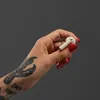Marshall Minor IV true wireless earbuds in Cream, earbud held between two fingers