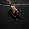 Marshall Middleton portable Bluetooth speaker in Black and Brass, held under water
