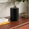 Sonos Era 100 Wi-Fi Bluetooth speaker in Black, on a wooden sideboard