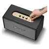 Marshall Stanmore IV Bluetooth home speaker in Black, hand pulling the power switch on the top panel