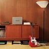 Marshall Woburn III Bluetooth home speaker in Cream, on a sideboard next to a record player