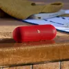 Beats Pill portable Bluetooth speaker in Statement Red, with water drops on its surface