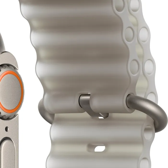 Apple Watch Ultra 4 in Natural Titanium with the Translucent Grey Ocean Band, close-up of the Digital Crown, side button and titanium buckle and loop