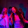 JBL EasySing Mics wireless karaoke microphones in Black, two friends singing karaoke at a party