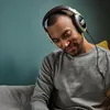 Sennheiser HD 599 open-back headphones in Ivory, worn while relaxing on a sofa